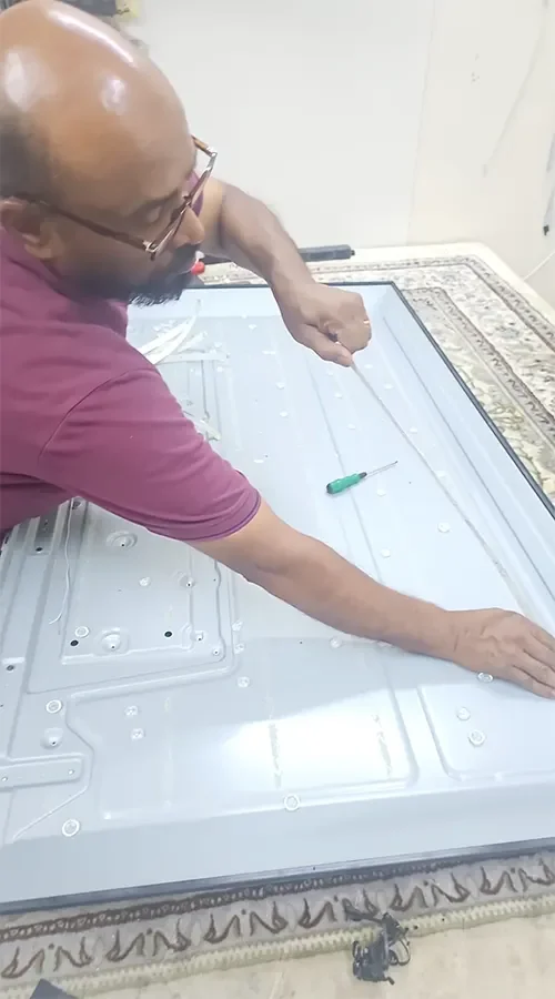 الفني كلاي فني تصليح تلفزيونات هندي أثناء صيانة شاشة داخل ورشة الفرسان في الكويت