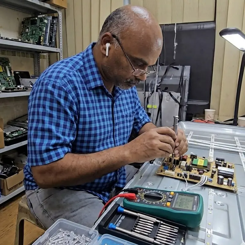 تصليح تلفزيونات في الكويت داخل الورشة بواسطة فني متخصص تصليح تلفزيونات في الكويت فني يقوم بفحص بوردة الشاشة داخل الورشة